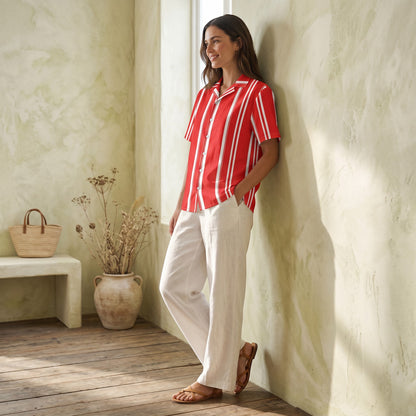 Good Wishes 365 red and white vertical striped short sleeve button-down shirt worn by a woman with white linen trousers.