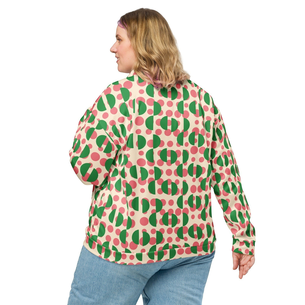 Good Wishes 365 unisex bomber jacket with pink polka dots and green semi-circles on cream, back view on a woman