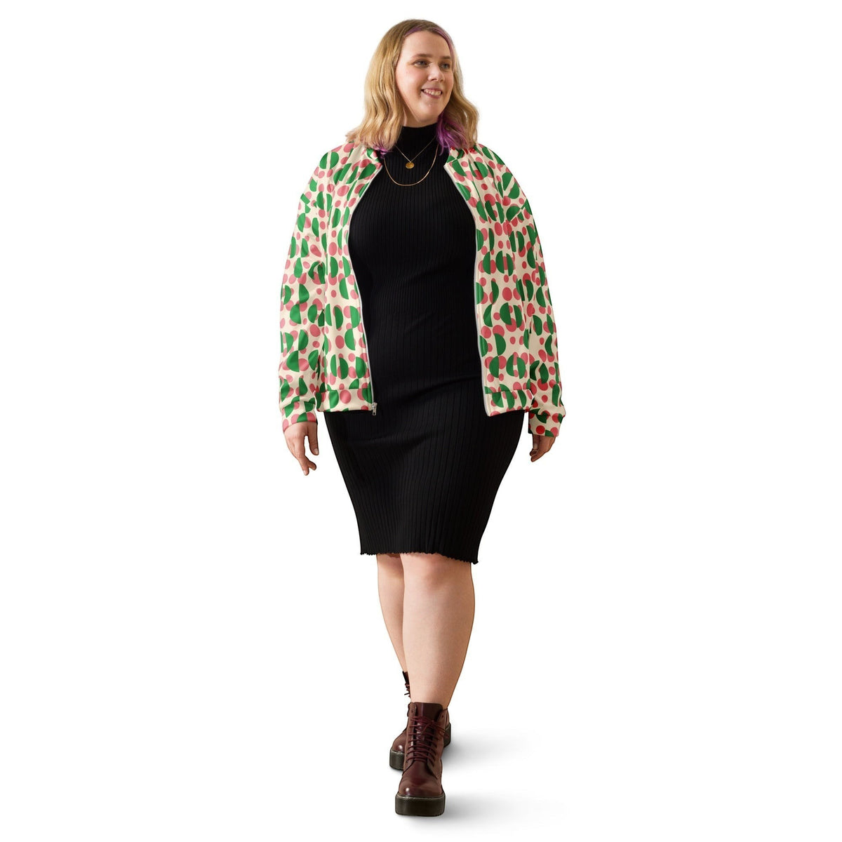 Good Wishes 365 bomber jacket with pink polka dots and green semi-circles worn by a woman over a black ribbed dress