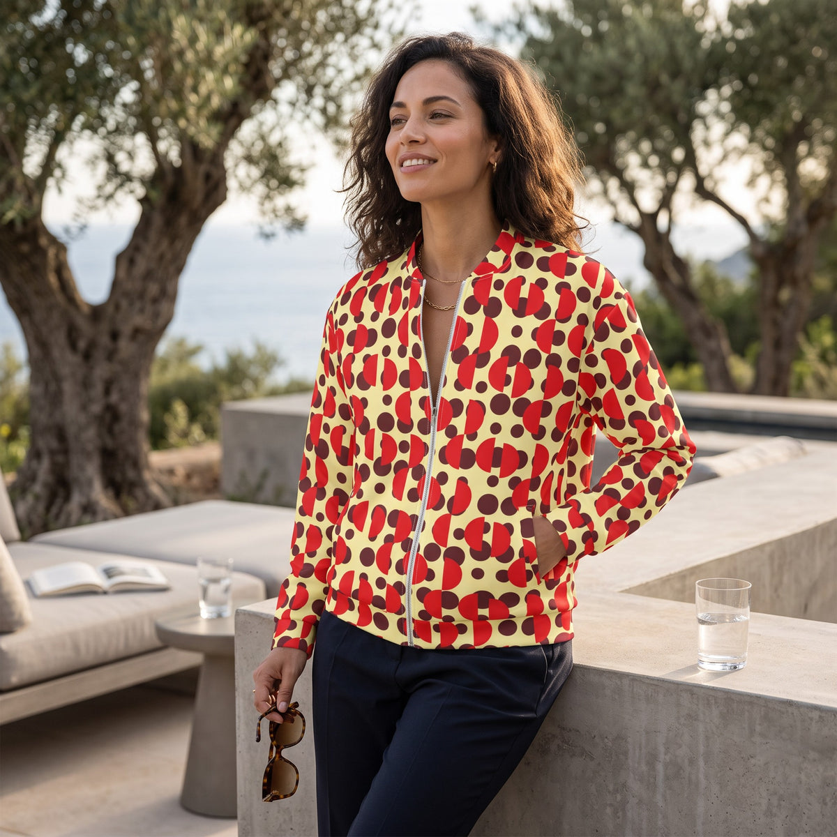 Woman wearing a Good Wishes 365 bomber jacket with a yellow, brown, and red retro polka dot and semi-circle print.