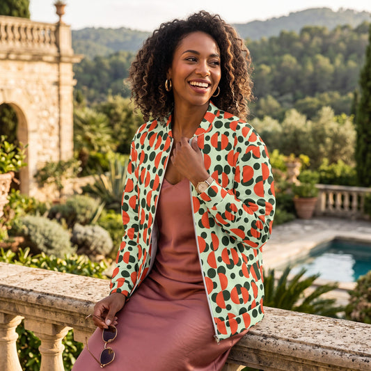 Good Wishes 365 unisex bomber jacket with green retro polka dot and orange semi-circle print worn by a smiling woman.