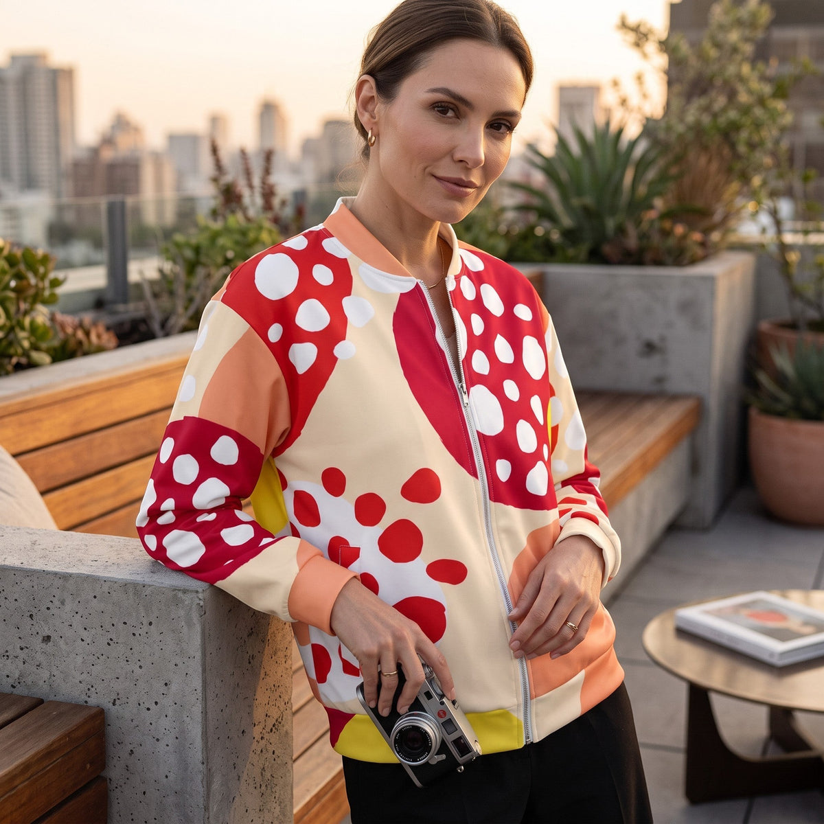 Good Wishes 365 unisex bomber jacket with red strawberry print, silver zipper, and brushed fleece lining on a model.