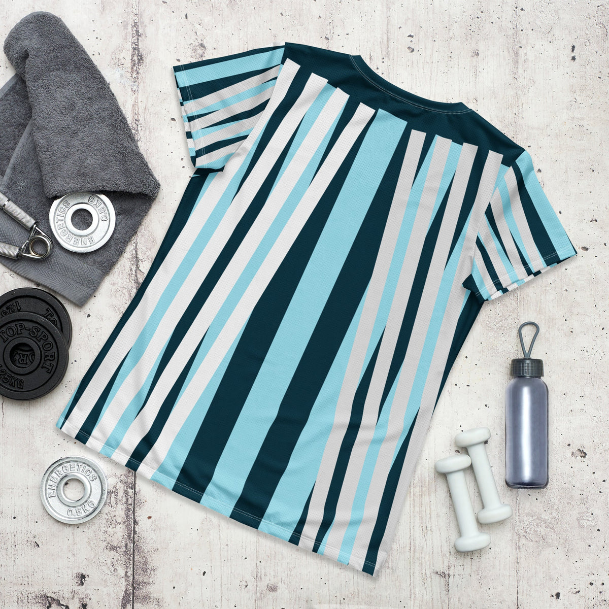 Good Wishes 365 women's athletic t-shirt with blue, white, and navy vertical stripes, laid flat with gym equipment.
