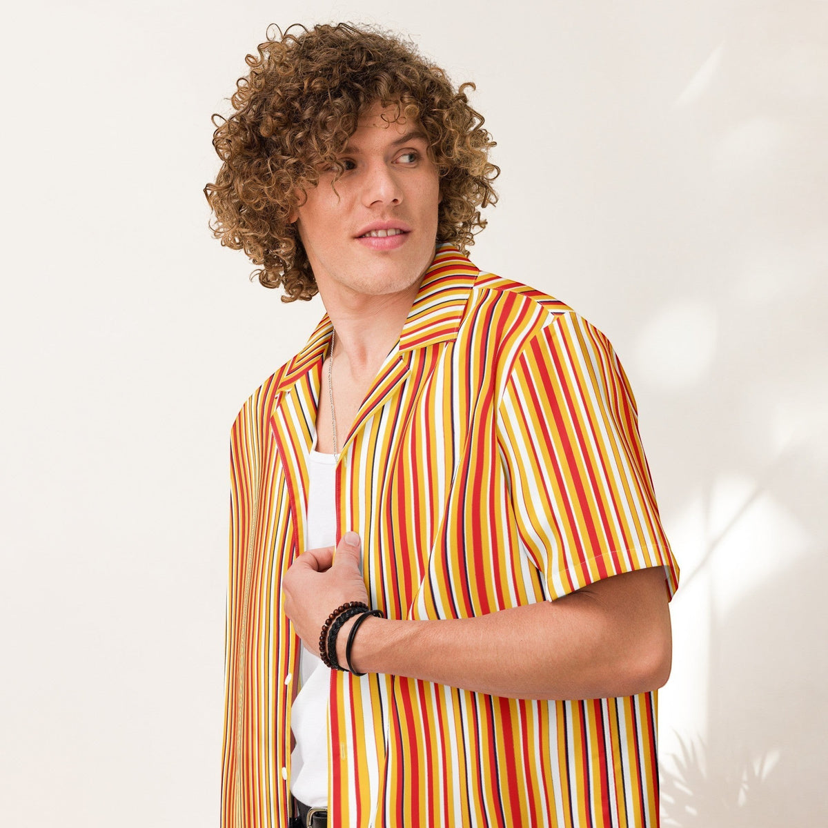 Good Wishes 365 men's yellow and blue striped short sleeve button shirt with an oversized fit on a curly-haired model