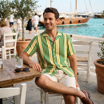 Good Wishes 365 men's yellow and blue vertical striped short sleeve camp collar shirt worn at a seaside cafe