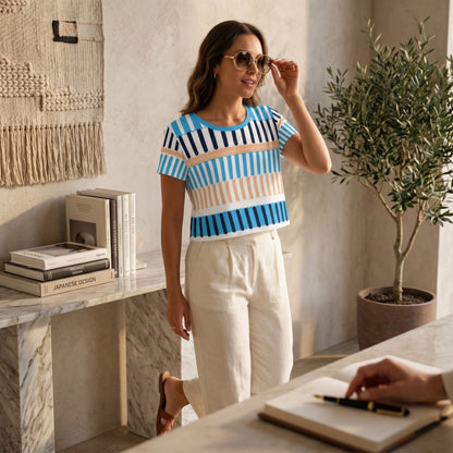Good Wishes 365 crop tee with blue and sand vertical stripe print worn by a woman with sunglasses in a bright room