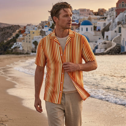 Good Wishes 365 unisex button shirt with orange and yellow stripes, worn by a man on a beach at sunset.