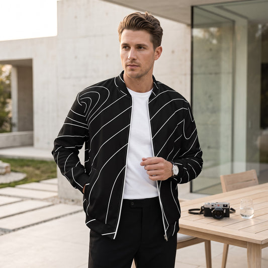 Good Wishes 365 black and white wave line print bomber jacket worn by a man in a modern outdoor setting.