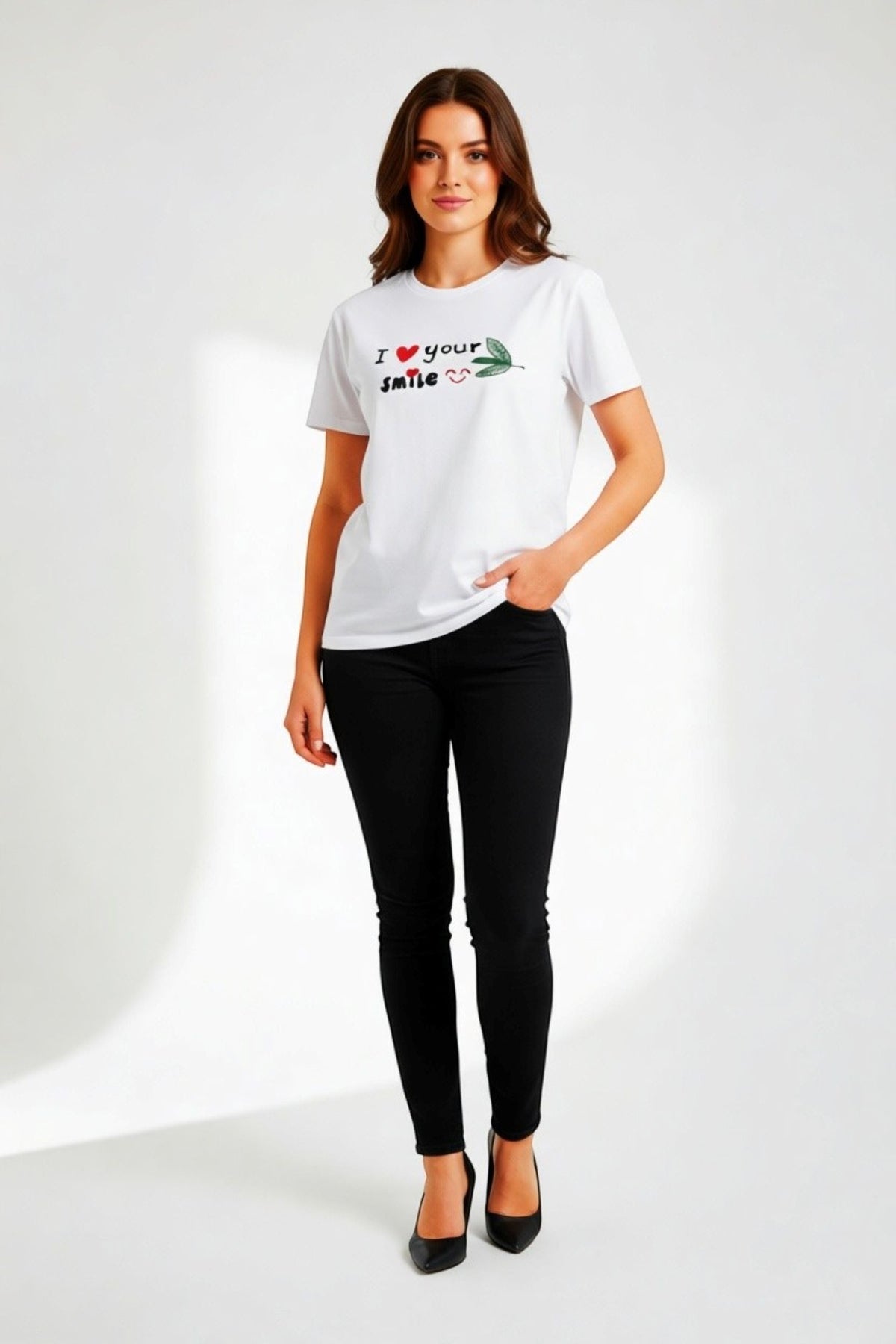 Good Wishes 365 white crewneck t-shirt with I Love Your Smile graphic worn by a woman with black jeans and heels