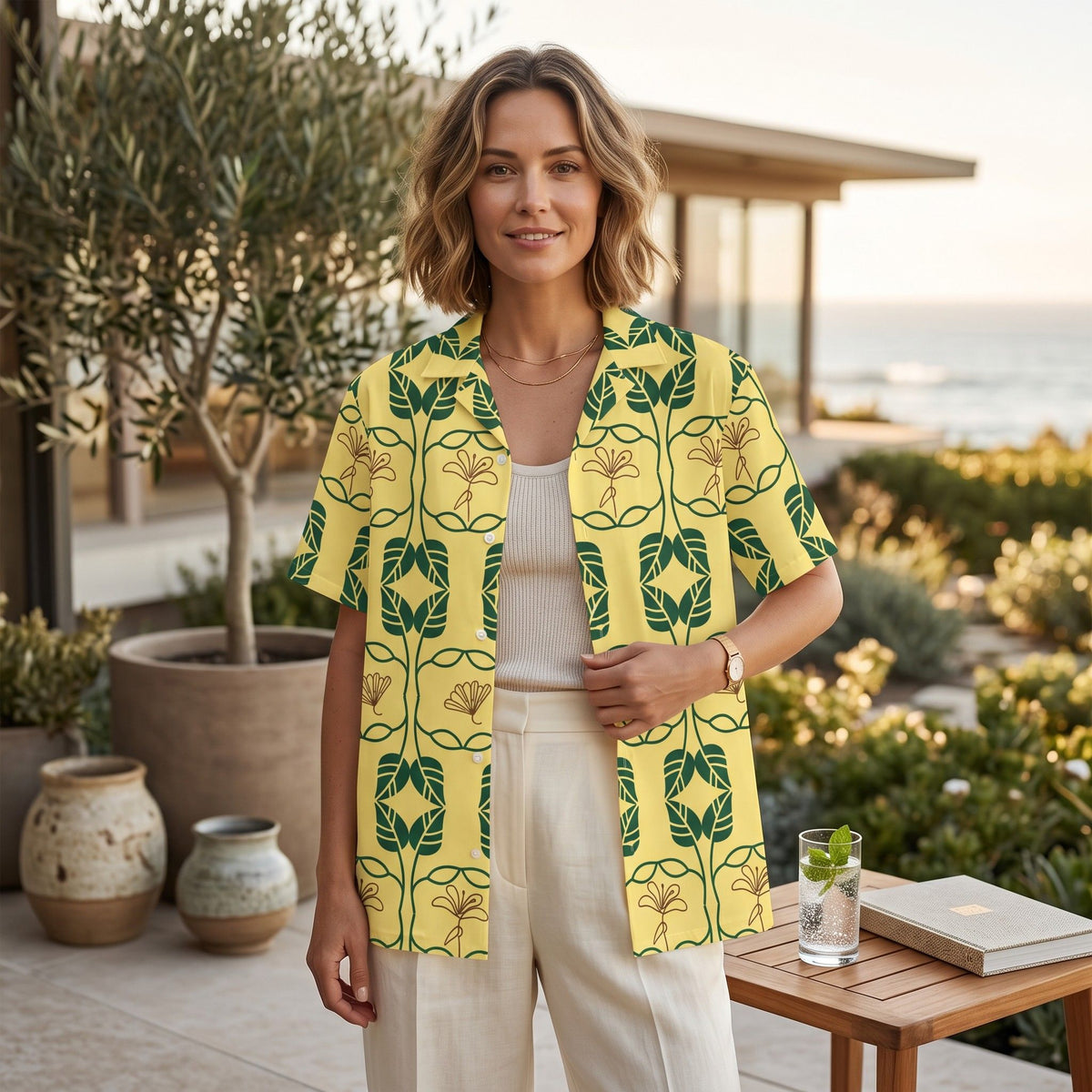 Good Wishes 365 yellow short sleeve button down shirt with green and gold botanical geo print worn by a woman outdoors