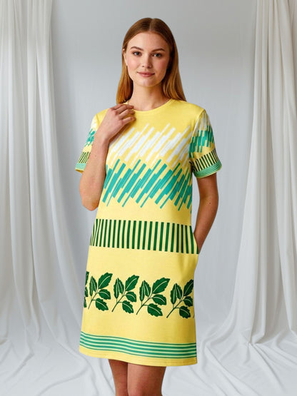 Good Wishes 365 yellow t-shirt dress with green leaf print and geometric pattern. Comfortable oversize fit, drop shoulders, mid-weight jersey.