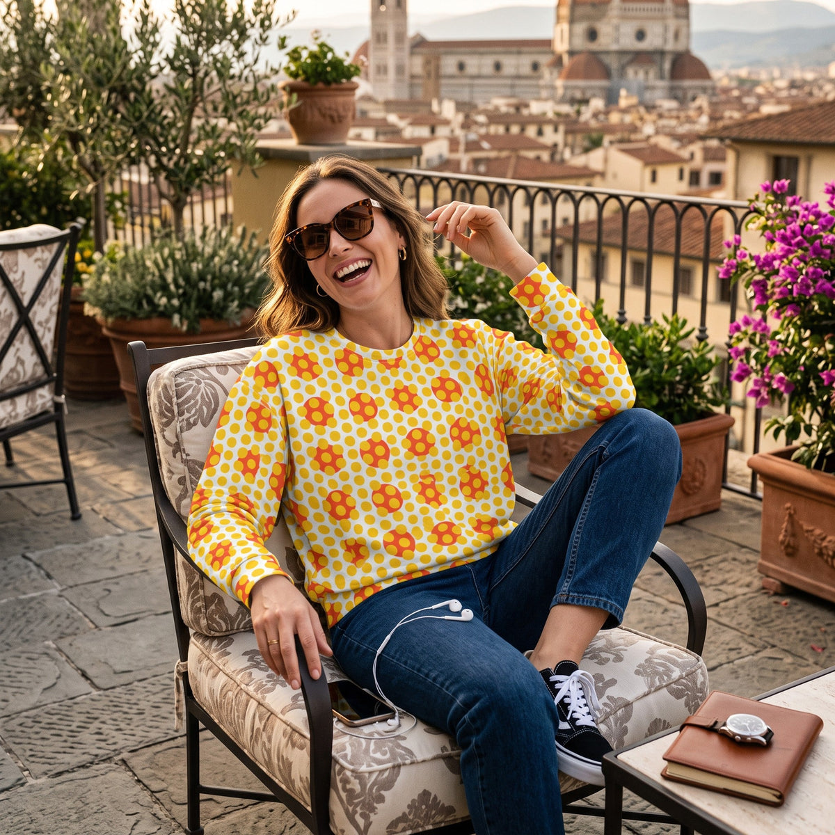 Good Wishes 365 yellow geometric pop art sweatshirt worn by a smiling woman on a sunny rooftop terrace in Florence.
