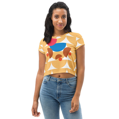 Good Wishes 365 yellow crop tee with geometric mushroom graphic in blue, red, and terracotta worn by a woman.